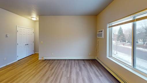 A room with a white door and a window showing a snowy street outside.