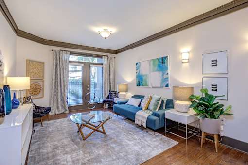 A living room with a blue couch and a white coffee table.