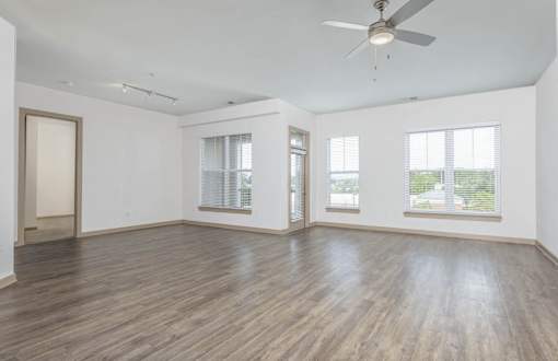 A room with wooden flooring and a ceiling fan.