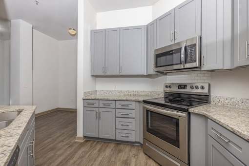 A kitchen with a stove, oven, and cabinets.