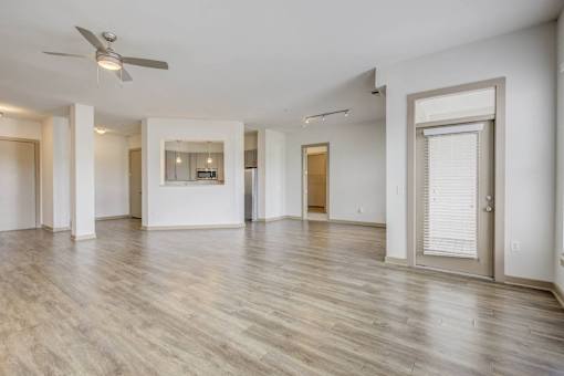 A spacious room with a ceiling fan and lighting fixture.