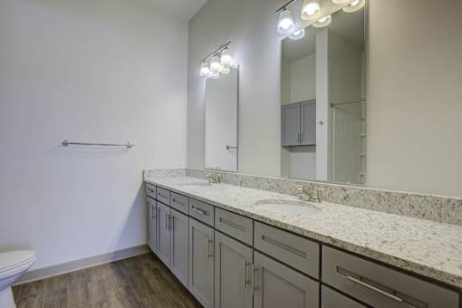 A bathroom with a marble countertop and a large mirror.