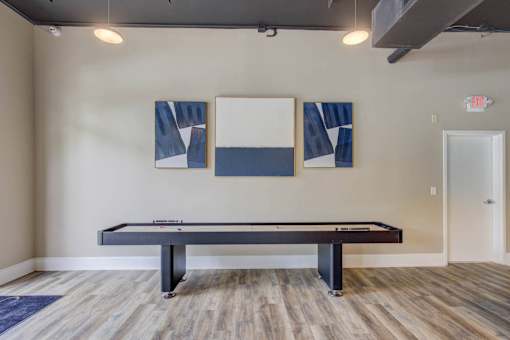 A pool table in a room with two framed pictures on the wall.