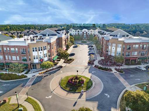 A roundabout in a residential area with apartment buildings on either side.