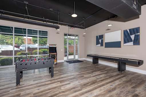 A room with a foosball table and a bench.