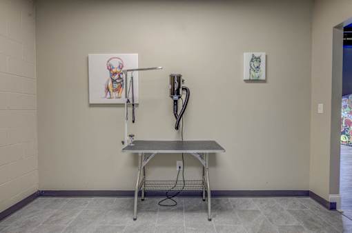 A room with a table and two paintings on the wall.