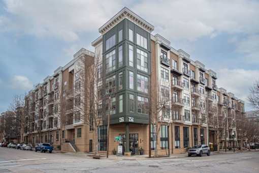 A large multi-story building with a green awning on the front.