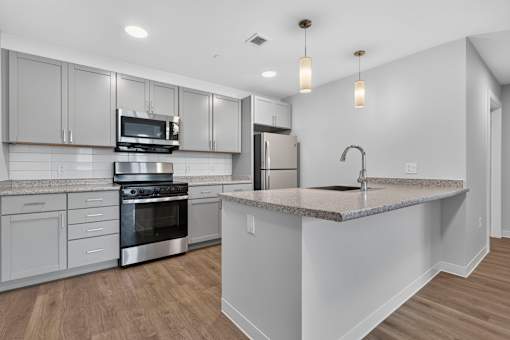 A modern kitchen with stainless steel appliances and a central island.