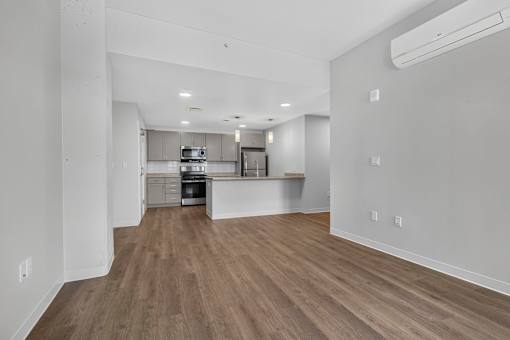 A kitchen with white cabinets and a wooden floor.