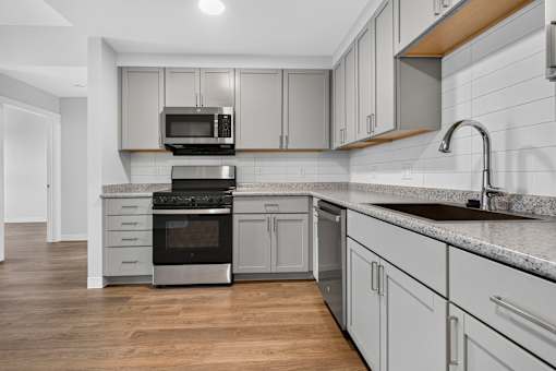 A modern kitchen with a stove, oven, and microwave.