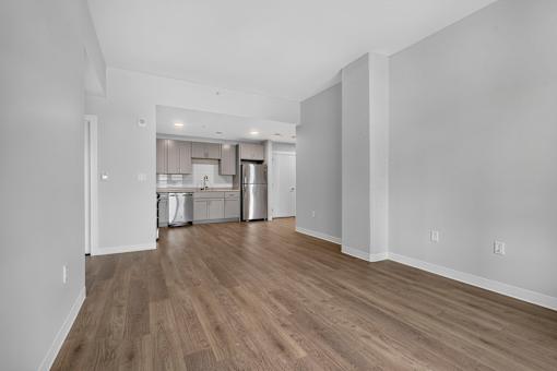 A kitchen with white walls and wooden floors.