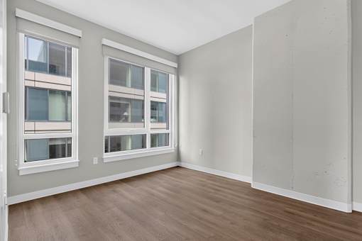A room with a window and wooden flooring.