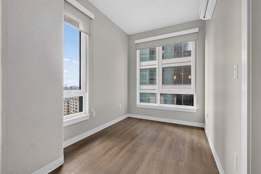 A room with a window and wooden flooring.