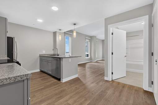 A kitchen with a granite countertop and wooden flooring.