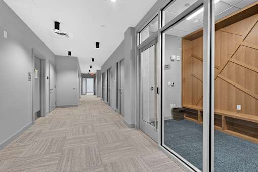 A long hallway with doors on both sides and a carpeted floor.