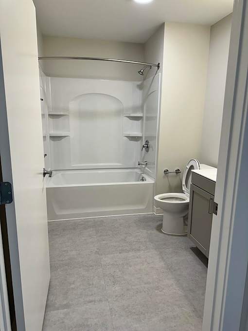 A white bathroom with a toilet, sink, and bathtub.