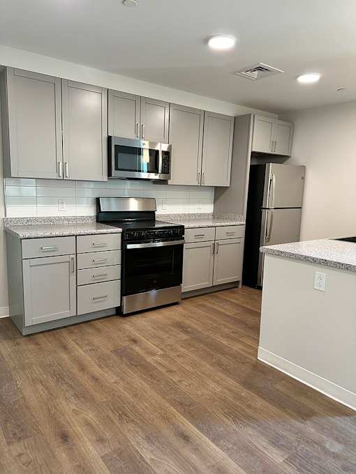 A kitchen with a stove top oven and a microwave above it.