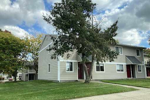 A house with a grey siding and red doors.