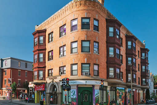 A large brick corner building with business on street level