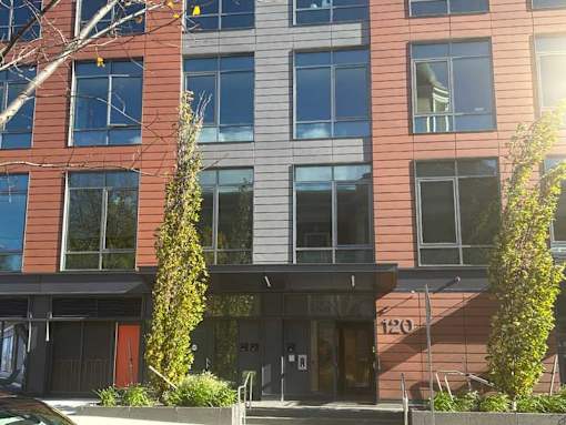 A modern building with a red door and a number 120 on the facade.