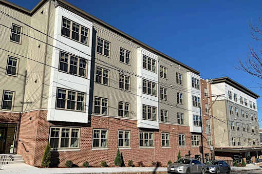 A multi-story building with a mix of brick and siding exterior.