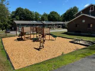 A playground with a swing set and a sandbox.