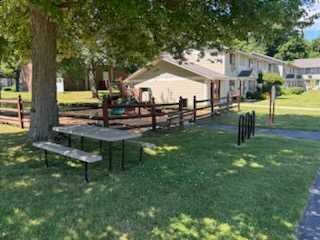 A park with a picnic table and benches.