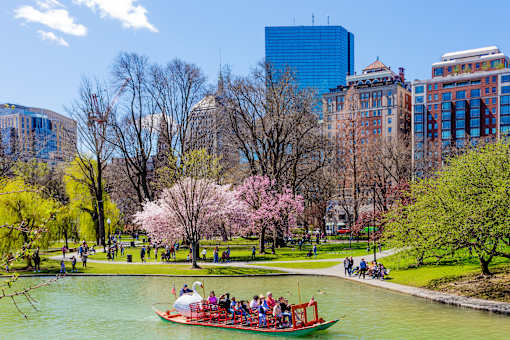 A boat full of people is on a river in a park.