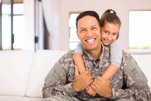 a man in a military uniform holding a girl on his lap