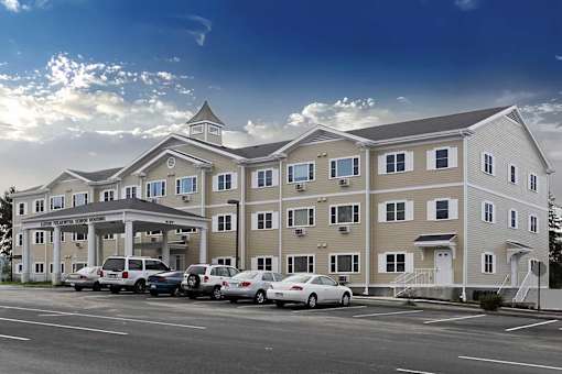 A large apartment complex with a parking lot in front.