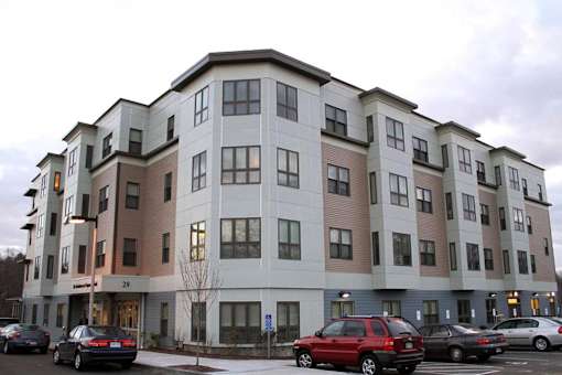 Apartment building with cars parked in front.