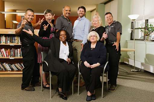 A group of people posing for a photo in a library.