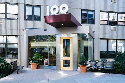 The front of a building with a red awning and a sign that reads 100.
