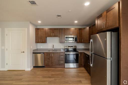 A modern kitchen with wooden cabinets and stainless steel appliances.