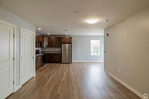 A kitchen with wooden floors and white walls.