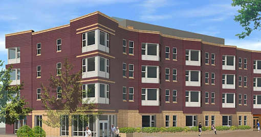 A red brick building with a tree in front of it.