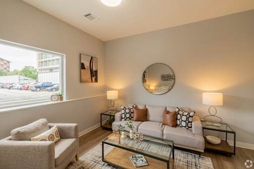 A living room with a couch, chair, and two lamps.