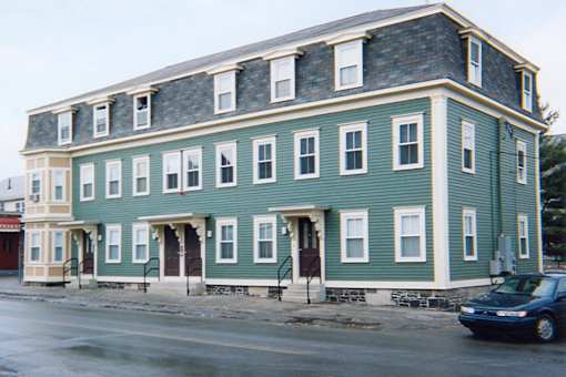 A green building with white trim and windows.