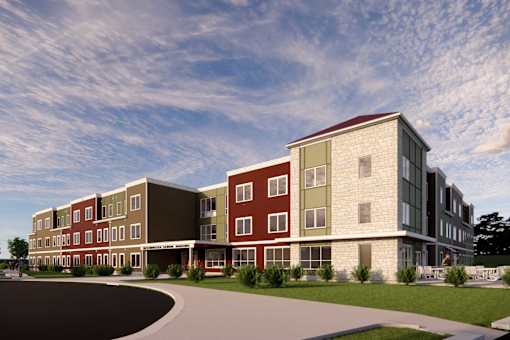 A modern building with a red roof and a parking lot in front.