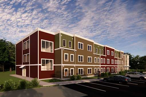 A modern apartment building with a parking lot in front.