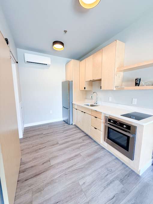 A kitchen with wooden cabinets and a stove top oven.
