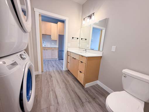 A bathroom with a washer and dryer in the corner.