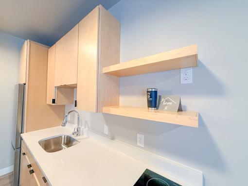 A kitchen with a sink and a refrigerator.
