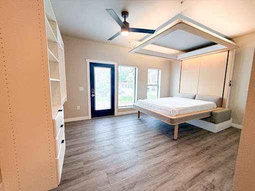 A bedroom with a bed, dresser, and window.