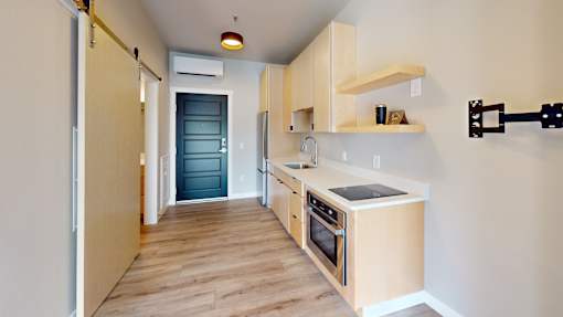 A kitchen with wooden floors and cabinets.