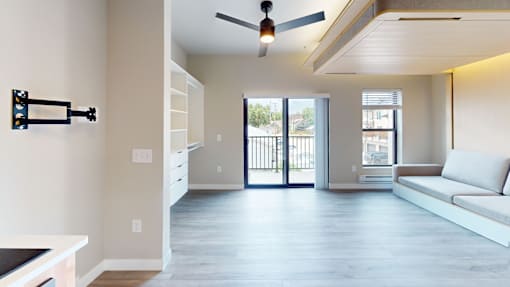 A modern living room with a sliding glass door leading to a balcony.