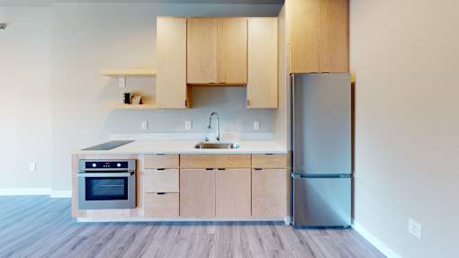 A kitchen with wooden cabinets and a stainless steel refrigerator.