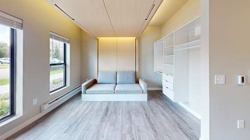 A modern living room with a grey sofa and a white cabinet.