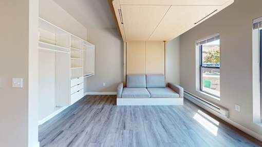 A modern living room with a grey floor and white walls.
