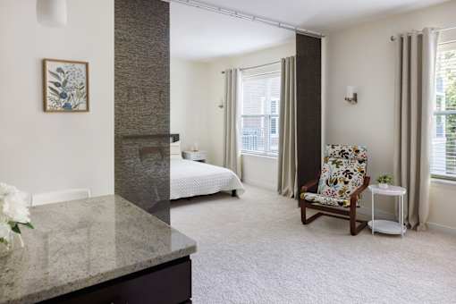 A room with a chair and a bed.